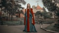 Charming young blonde princess in the medieval green dress with a red cape Royalty Free Stock Photo