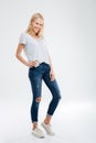 Beautiful young blonde girl putting smartphone in the jeans pocket Royalty Free Stock Photo