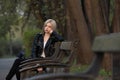 beautiful young blonde girl sitting on a Park bench Royalty Free Stock Photo