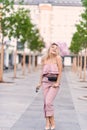 Beautiful young blonde girl in sunglasses with puffy lips and feminine body posing on the street style on sunny day