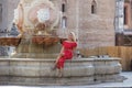 Beautiful young blonde girl from the United States is on a sightseeing trip in Seville, Spain. The woman is sitting on the edge of