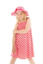 Beautiful young blonde girl wearing big pink floppy hat and a polka dot dress. Isolated on white studio background Royalty Free Stock Photo