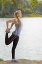 Beautiful young blonde woman with athletic body doing stretching exercise outdoors Royalty Free Stock Photo