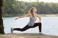 Beautiful young blonde woman with athletic body doing stretching exercise outdoors Royalty Free Stock Photo