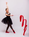 Beautiful young blonde woman ballet gymnast training calilisthenics exercise with red ribbon with red shoes Royalty Free Stock Photo