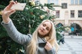 A beautiful young blonde woman or girl doing selfie or photographing.