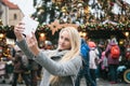 A beautiful young blonde woman or girl doing selfie or photographing.