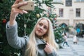 A beautiful young blonde woman or girl doing selfie or photographing.