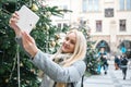 A beautiful young blonde woman or girl doing selfie or photographing.