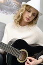 beautiful young blonde woman with hat playing the acoustic guitar Royalty Free Stock Photo