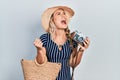 Beautiful young blonde woman holding vintage camera angry and mad screaming frustrated and furious, shouting with anger looking up Royalty Free Stock Photo