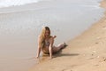 Beautiful young blonde woman lying on the shore of the beach. The woman is sunbathing and enjoying the holiday and the sea. Travel Royalty Free Stock Photo