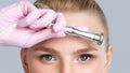 Beautiful young blonde woman with makeup,clean fresh skin naked shoulders holds a nozzle for microdermabrasion in her hands.