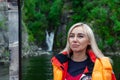 Beautiful Young Blonde Woman In An Orange Life Jacket Sits In A Motor Boat During An Excursion And Sailing On Lake Teletskoye In