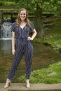 Beautiful young blonde woman poses in front of waterfall Royalty Free Stock Photo