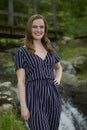 Beautiful young blonde woman poses in front of waterfall Royalty Free Stock Photo