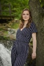 Beautiful young blonde woman poses in front of waterfall Royalty Free Stock Photo