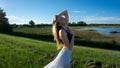 young blonde woman posing against the wind in landscape with peaceful face during sunset skirt & hair blown by the wind Royalty Free Stock Photo