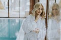 Beautiful young blonde woman relaxing at indoor swimming pool Royalty Free Stock Photo