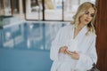 Beautiful young blonde woman relaxing at indoor swimming pool Royalty Free Stock Photo