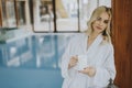 Beautiful young blonde woman relaxing at indoor swimming pool Royalty Free Stock Photo