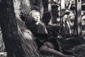 Beautiful young blonde woman sitting near the hay in the yard in rural areas. black-white Royalty Free Stock Photo