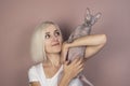 Beautiful young blonde woman smiles and holds in her arms a bald Sphynx cat Royalty Free Stock Photo