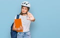 Beautiful young blonde woman wearing backpack and bike helmet with open hand doing stop sign with serious and confident Royalty Free Stock Photo