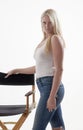 Beautiful young blonde woman in white tank top and blue jeans Royalty Free Stock Photo