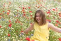 a beautiful young blonde woman in a yellow dress stands among a flowering field Royalty Free Stock Photo