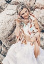 Beautiful young boho style woman in white dress on stone beach Royalty Free Stock Photo