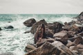 Beautiful young boho styled woman sitting on a stone beach