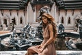 Beautiful young boho woman in elegant dress at the ancient temple background