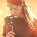 Beautiful young boho woman in summer meadow hold flower sunlight Royalty Free Stock Photo