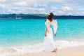 Beautiful young bride with angel wings on the sea coast. Tropical sea in the background.