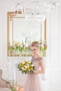 A beautiful young bride with a bouquet of yellow and white spring flowers