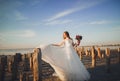 Beautiful young bride with bridal bouquet posing on the background sea Royalty Free Stock Photo