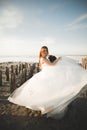 Beautiful young bride with bridal bouquet posing on the background sea Royalty Free Stock Photo