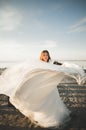 Beautiful young bride with bridal bouquet posing on the background sea Royalty Free Stock Photo