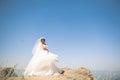 Beautiful young bride with bridal bouquet posing on the background sea Royalty Free Stock Photo