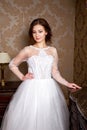 Beautiful young Bride with brunette hairs in a bedroom. Classic white wedding dress. Close up portrait Royalty Free Stock Photo