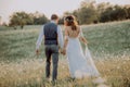 Beautiful bride and groom at sunset in green nature. Royalty Free Stock Photo