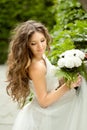 Beautiful young bride with long wavy hair and wedding makeup ho