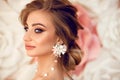 Beautiful young bride with makeup and fashion wedding hairstyle. Closeup portrait of young gorgeous woman over roses flowers. Royalty Free Stock Photo