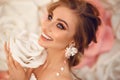 Beautiful young bride with makeup and fashion wedding hairstyle. Closeup portrait of young gorgeous woman over roses flowers. Royalty Free Stock Photo