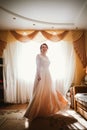 Beautiful young bride near the window in full growth Royalty Free Stock Photo