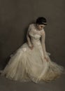 Beautiful young bride settling her vintage wedding dress