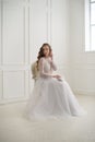 Beautiful young bride sitting on a chair in white room with hand Royalty Free Stock Photo