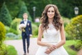 Beautiful young bride standing on lane in summer park Royalty Free Stock Photo