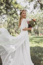 beautiful young bride in wedding dress holding bouquet of flowers and smiling at camera Royalty Free Stock Photo